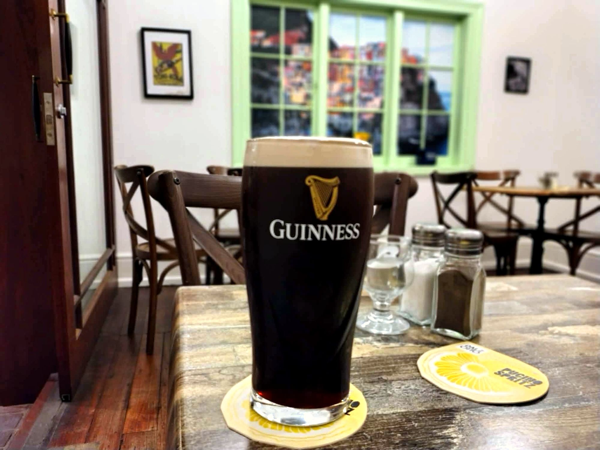 A pint of Guinness settling on a table in the warm front room of Whatley's Bar