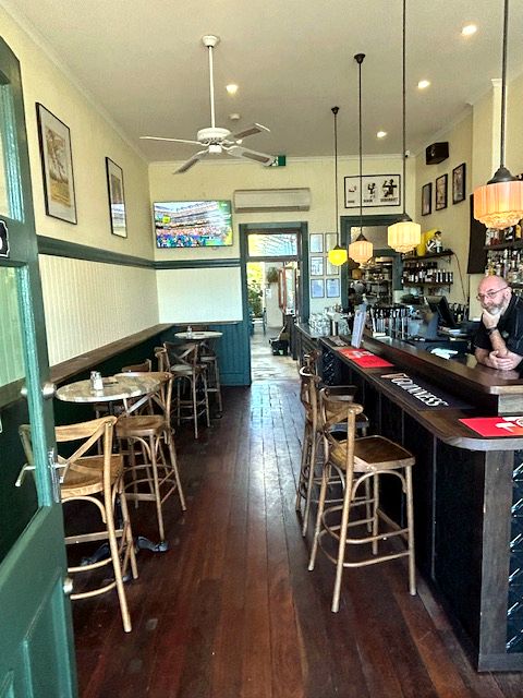 The timber-floored front bar at Whatley's, stools pulled up along the counter